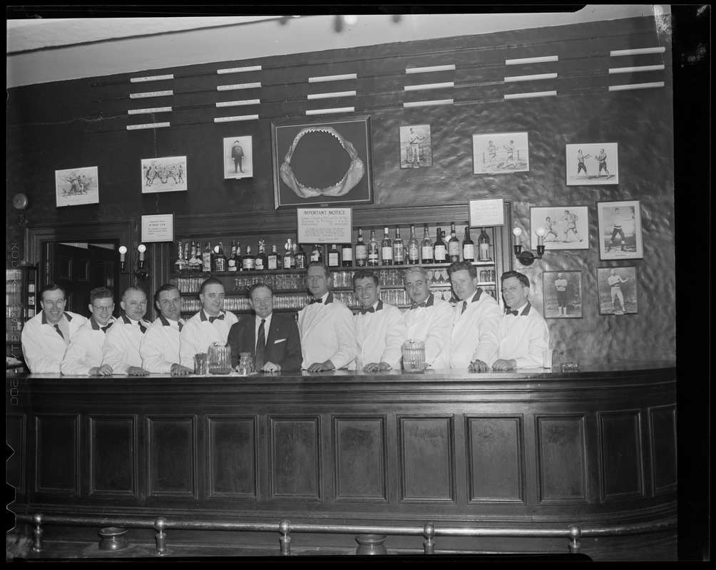 Bar staff poses under shark jaw