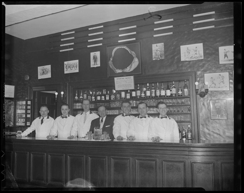 Bar staff poses under shark jaw