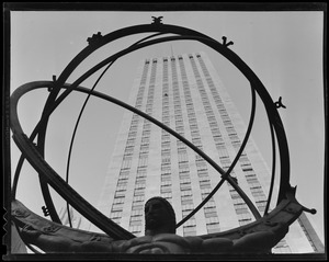 New York City Radio City Building showing window washer at work. The one shooting through steel ring is the International Building on 5th Ave., also showing window washer at work.