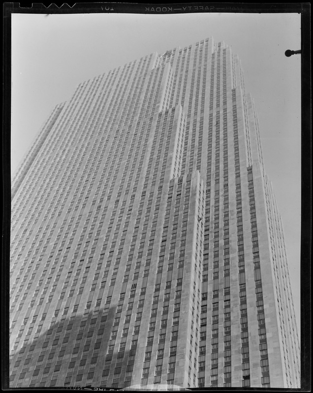 New York City Radio City Building showing window washer at work. The one shooting through steel ring is the International Building on 5th Ave., also showing window washer at work.