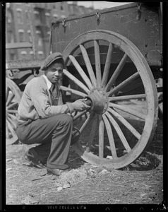 Man working on wagon wheel - African-American?