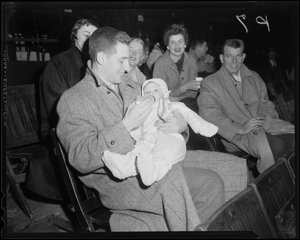 Man feeding baby in sports stand