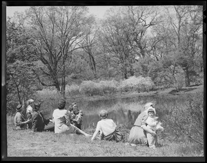 Women & children seated next to pond
