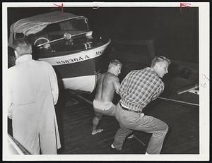 One of Hundreds of boats hauled to safety before approach of Donna is this one at Boston Harbor Marina in Squantum. Boat owned by Frank Hart of Arlington is pulled up on skids by James Nally, left, of Cambridge and unidentified boat owner doing a good turn.