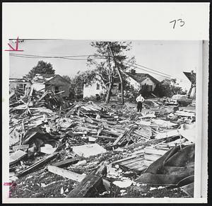 Standing Amid sea of splintered lumber, a Waterbury, Conn., residents surveys damage done by tornado that slashed through parts of city and surrounding town. One man was killed when a tree fell upon him as he hurried to shelter.