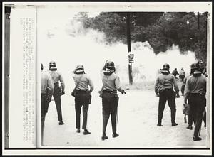 Police Push--Masked state police are shown as they drove antiwar demonstrators from the Ft. Dix Army reservation today with the help of tear gas. Several hundred had smashed through a barbed wire fence onto the reservation.