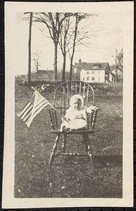 Baby in Windsor chair holding flag