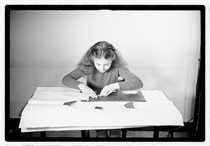 A girl matching fitting shapes in a puzzle
