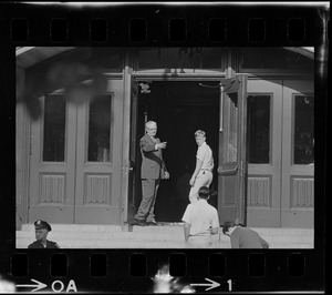 Headmaster Joseph Malone and a student standing in the doorway of English High School, most likely during student demonstrations