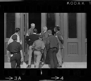A crowd of men and possibly students speaking to Headmaster Joseph Malone from a doorway at English High School, most likely during student demonstrations