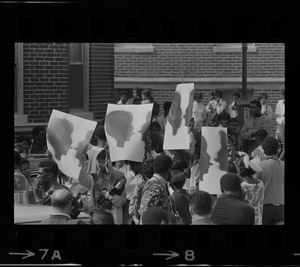 Demonstrators in the street with posters, most likely on Washington Street, near Jeremiah E. Burke High School in Dorchester