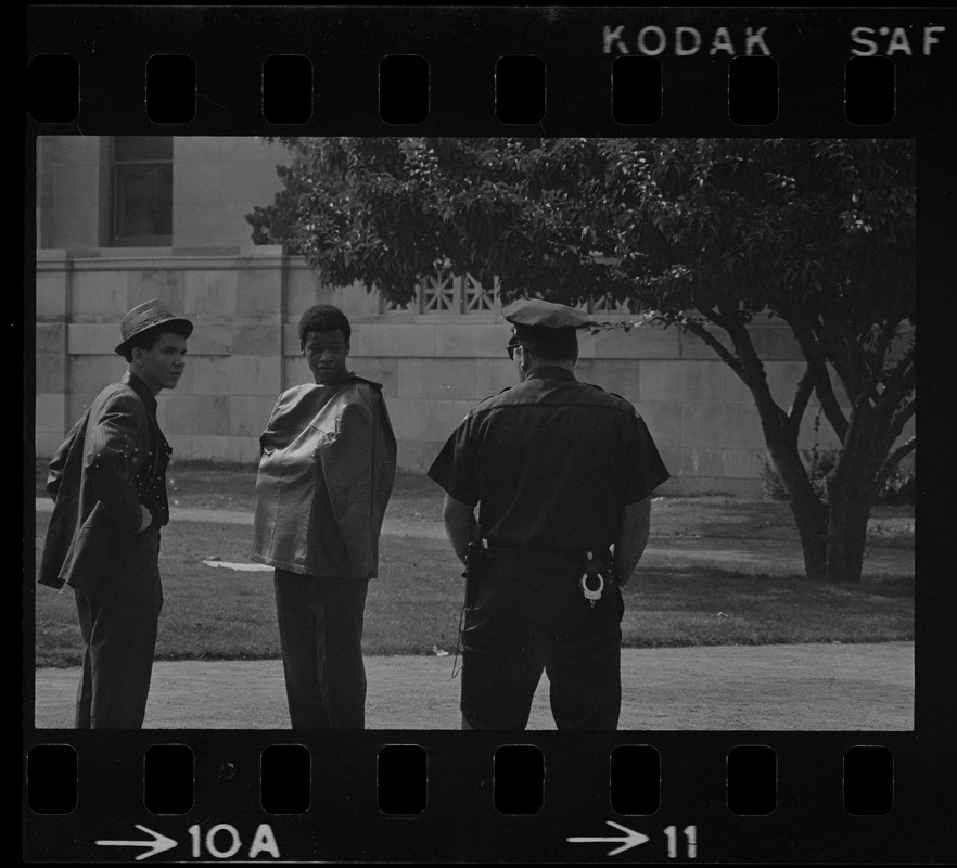 Police officer talking to two students, most likely during student demonstrations at nearby English High School