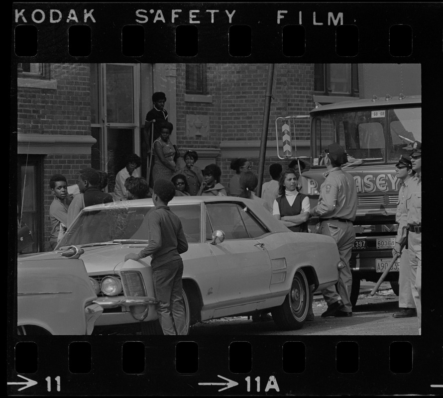 Group of people, including police, around trouble spot of Washington St., Dorchester during unrest following Black student rally