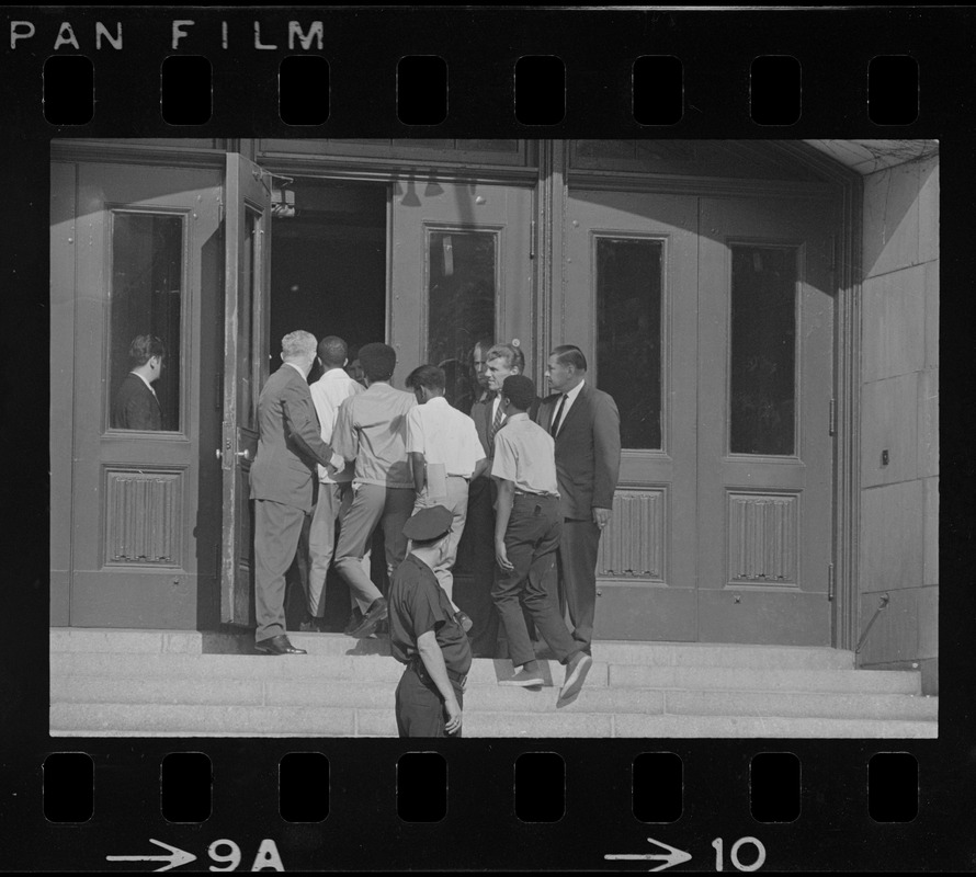 Headmaster Joseph Malone of English High School, far left, waving students through door, most likely during student demonstrations