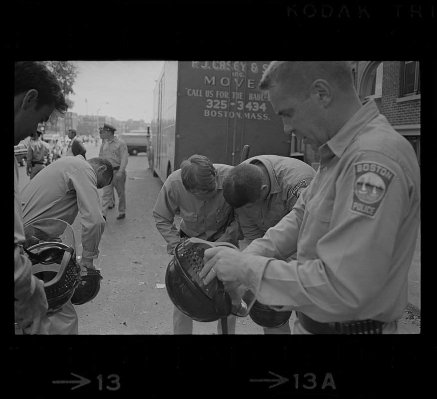 Policemen putting on helmets, while on Washington Street, Dorchester, during student demonstrations