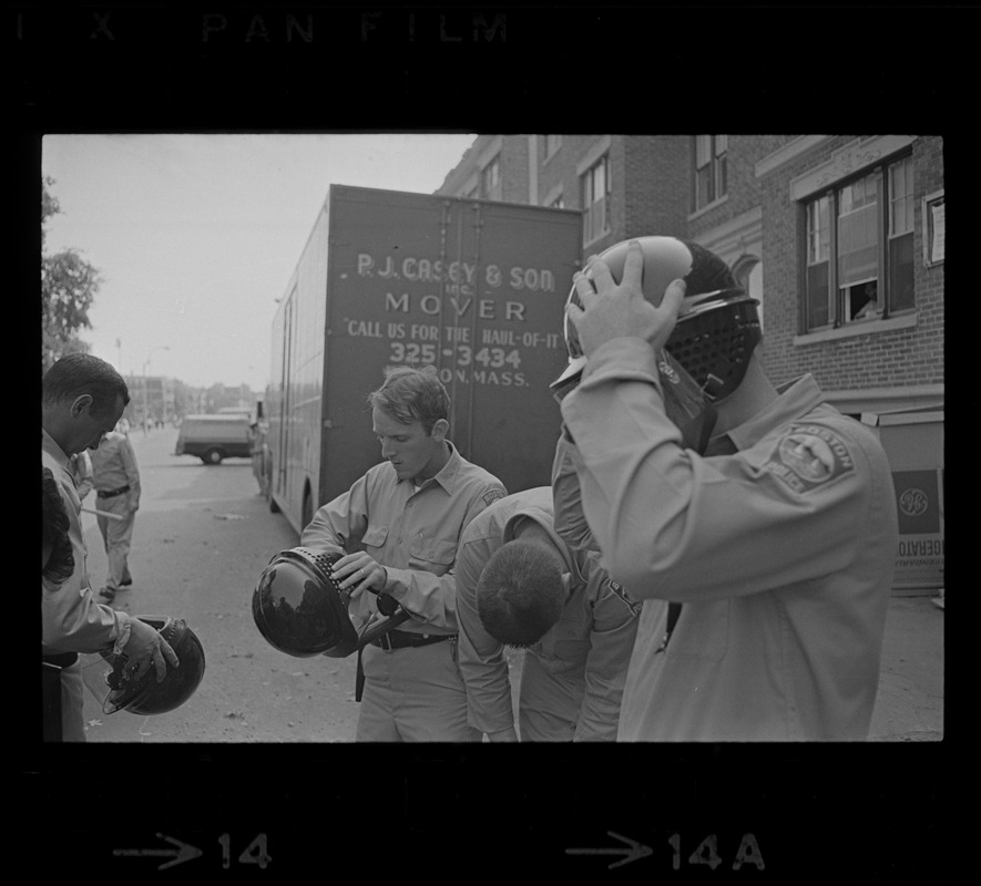 Policemen putting on helmets, while on Washington Street, Dorchester, during student demonstrations