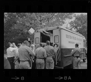 Unidentified man throwing box out of Boston Police Department Emergency Unit van to crowd of police officers, most likely near Jeremiah E. Burke High School after unrest broke out during student demonstrations