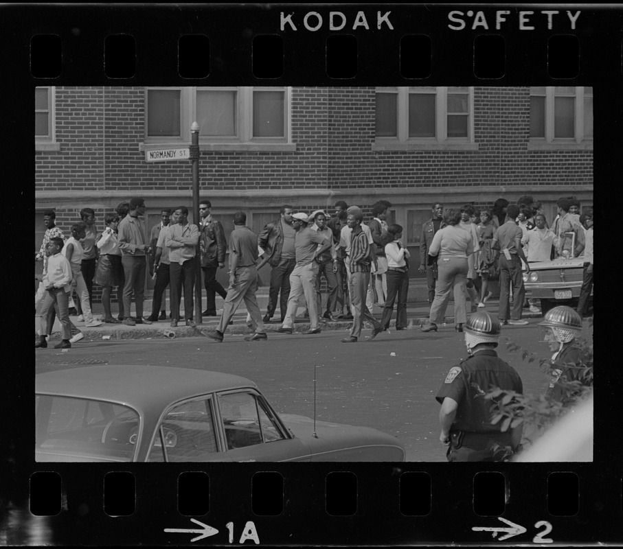 Crowd of people gathered in front of building on Washington Street, near Jeremiah E. Burke High School in Dorchester, during student demonstrations