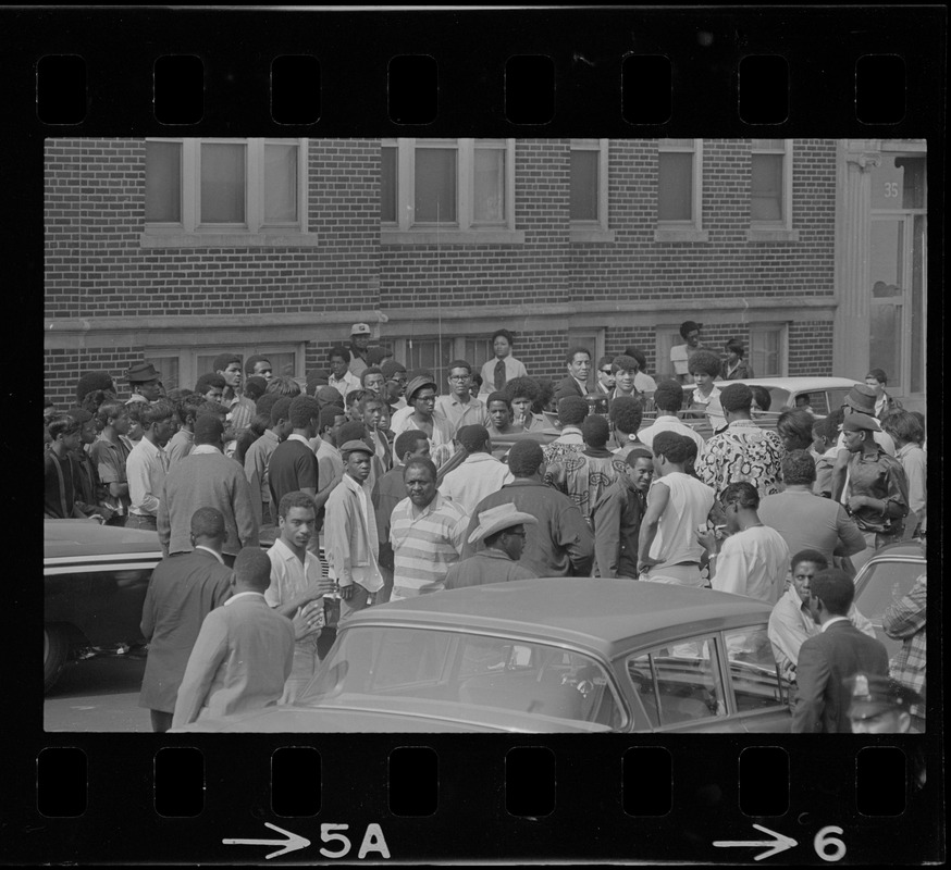Crowd in middle of Washington Street near Jeremiah E. Burke High School during time of student demonstrations