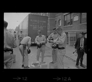 Police on Washington Street near Jeremiah E. Burke High School putting on riot gear after unrest broke out during student demonstrations