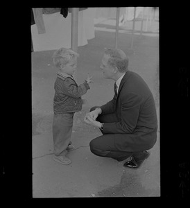 Kevin White talks to a young child while campaigning for mayor in the D St. Housing Project in South Boston