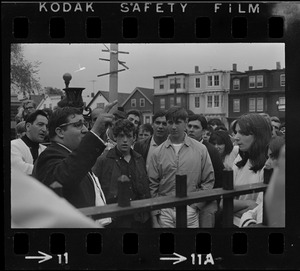 Unidentified man standing by gate of East Boston High School speaking to students during demonstrations
