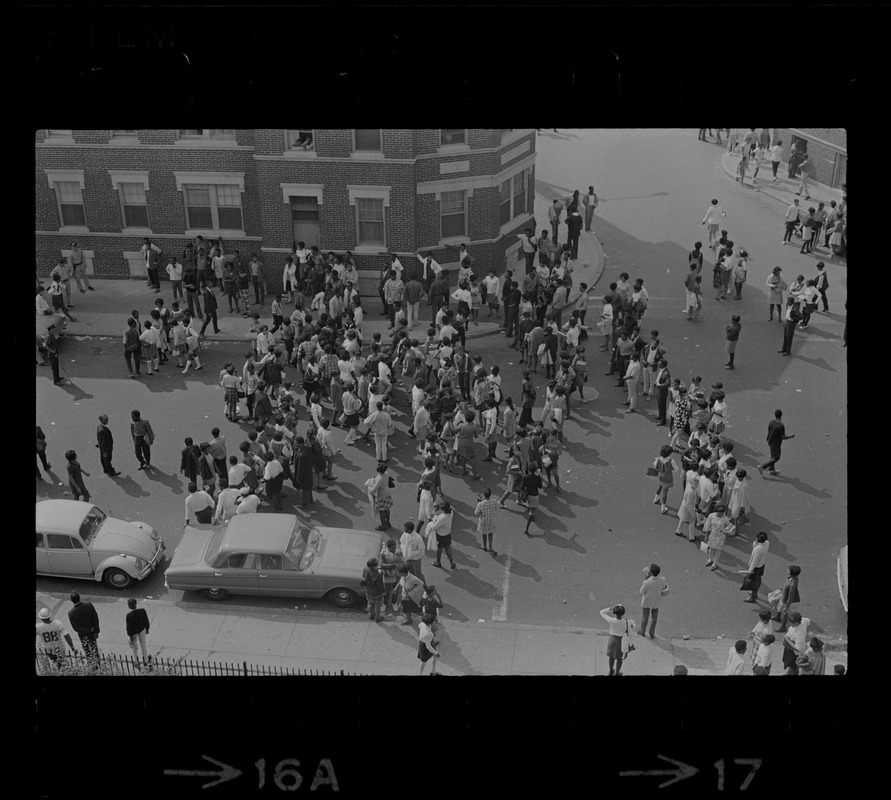 Birdseye view of crowd spilled into street, most likely students in front of Jeremiah E. Burke High School during student demonstrations