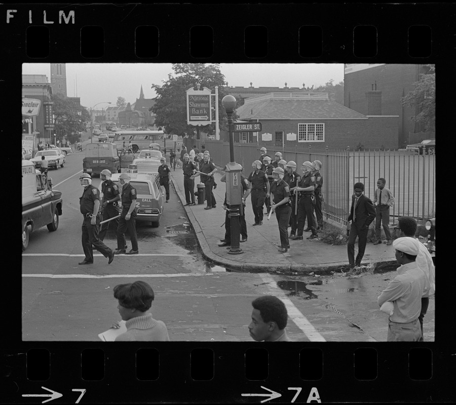 Riot police gathered on corner of Zeigler Street, near National Shawmut Bank, most likely close to site where a car was set afire in Roxbury during time of student demonstrations