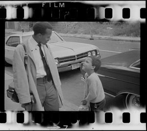 Unidentified boy and Black man talking on the sidewalk, most likely during the time of student demonstrations