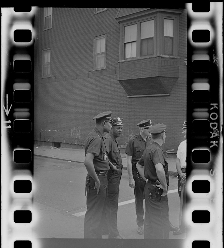 Group of police officers standing in a street, most likely during time of student demonstrations at nearby high schools