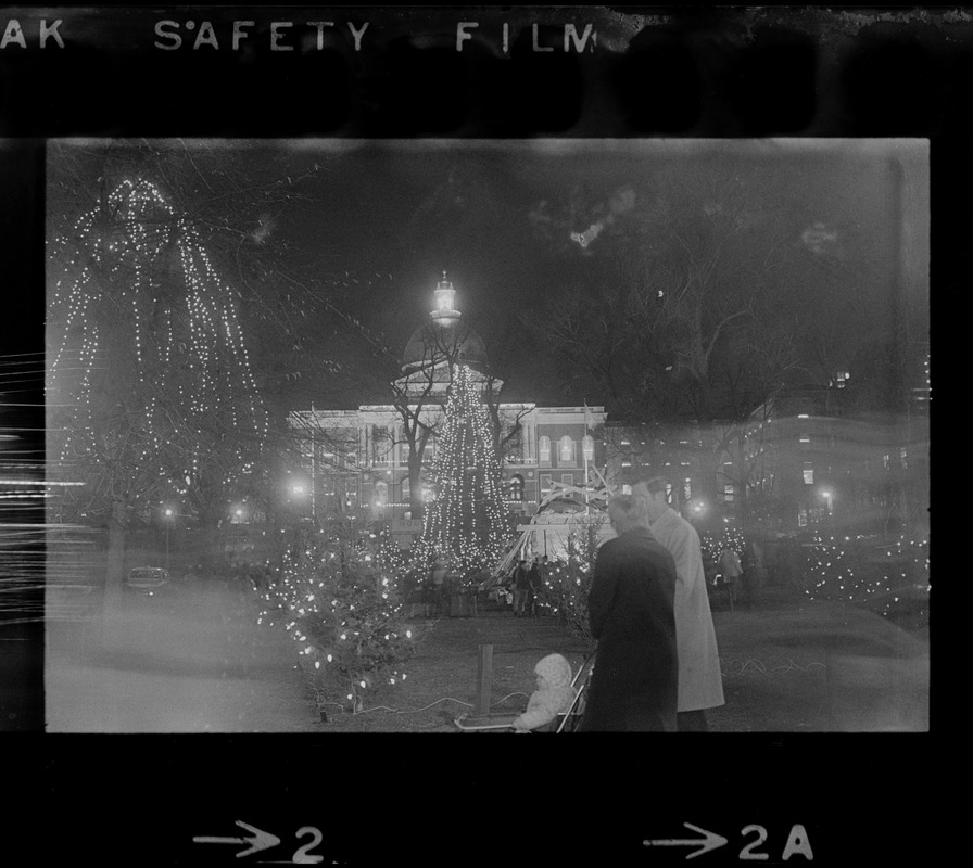 Now that Christmas season is officially upon us and the Boston Common is buried under a sea of lights, shoppers like this man and wife and their baby will take time out from their hurried schedules to enjoy the brightness and spirit of the holidays