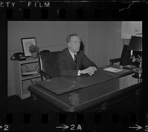 Boston young mayor Kevin White seated at his desk in City Hall and answering questions