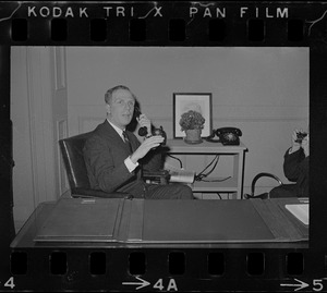 Boston young mayor Kevin White taking a call from his desk at his office in City Hall