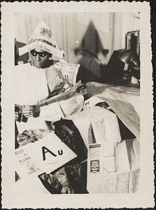 Jack Miller sits at typewriter wearing costume made of newspaper