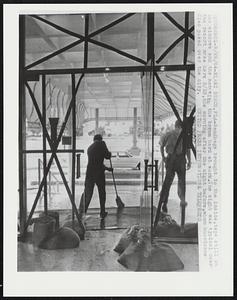 Sandbags brought to the inside, tape still on the windows and the man with the broom hard at work. The sight was typical over the resort area here 8/28, the morning after the night before, when hurricane Cleo passed over the city.