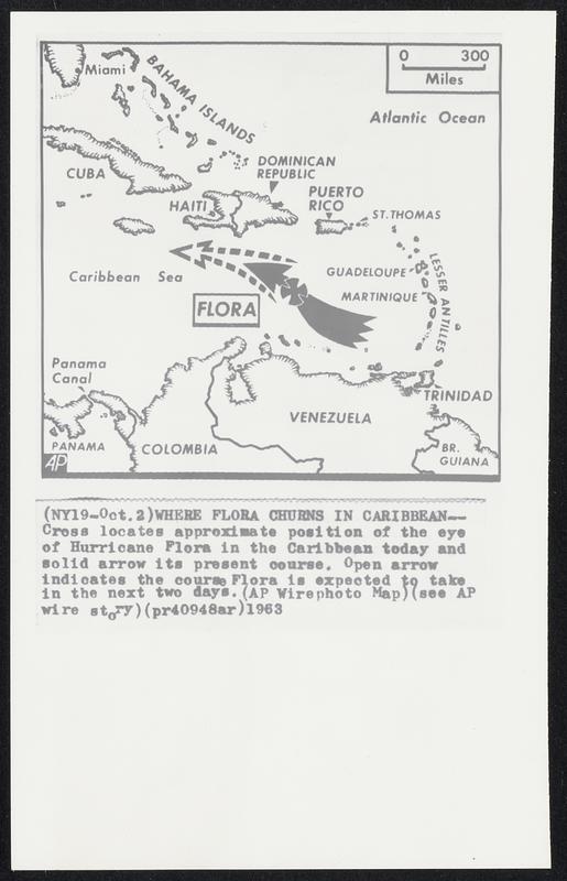 Where Flora Churns in Caribbean--Cross locates approximate position of the eye of Hurricane Flora in the Caribbean today and solid arrow its present course. Open arrow indicates the course Flora is expected to take in the next two days.