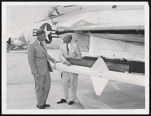 Raytheon Visitor - Defense Secretary Neil H. McElroy, left, chats with Charles F. Adams president of Raytheon Manufacturing Co., at Bedford Airport. McElroy, here for two-day visit, and Adams are shown with Sparrow III rocket on Navy F4D fighter interceptor plane. Rocket is made by Raytheon.