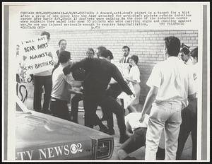 Chicago- A downed, anti-draft picket is a target for a kick after a group of men going into the Army attacked the anti-draft pickets outside induction center here early 8/4. About 15 draftees were walking in the door of the induction center when suddenly they waded into some 50 pickets who were carrying signs and chanting against war. No one was injured seriously enough to require hospitalization.