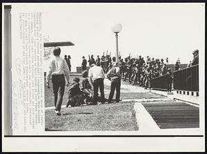 Campus Shooting Scene- A group of youths cluster around a wounded person, left foreground, as Ohio National Guardsmen hold their weapons up last Monday on Kent State University campus. Four Kent State students were killed and nine wounded in a confrontation between students and guardsmen. This photograph was made by Kent State student photographers Douglas Moore.
