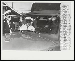 Four Wounded in Strike Violence - Robert Griffin (left) and Jack Brimberry, Covington policemen, look over the bullet-punctured windshield of a truck in which three employes of the strikebound Louisville & Nashville railroad were wounded today in a shooting affray at the Decoursey yards, near here. A fourth man, a bystander, was shot in the back. The shooting occurred as the truck, loaded with L & N employes passed through a picket line.