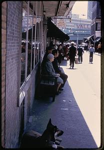 People sitting under an awning near Salem Wholesale Supply Co., Salem Street, North End