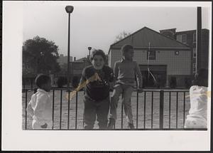 Group of children sitting on fence outside of Newtowne Court