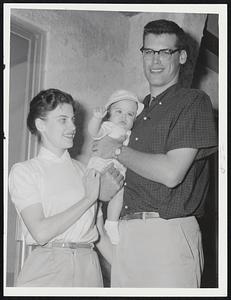Pitcher Dave Sisler and Family at the Red Sox spring training camp in Sarasota, Fla. Mrs. Janey Sisler beams as David George is either waving to the Traveler photographer or showing that he, like Pop, is a right-handed pitcher. Young David is not Junior because his father is David Michael. The baby is named David, for his father, and George, for his grandfather.