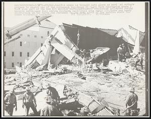 A crane is brought into place as hard hat workers prepare to search one of the collapsed buildings at Olive View Sanitarium where 3 died when part of the new $23 million "earthquake-proof" sanitarium collapsed during massive earthquake that struck Southern California area early 2/9. There was heavy destruction in the North San Fernando Valley area north of Los Angeles where the quake apparently centered.