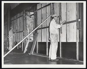 In Boston's Financial District, workers board up the windows of the United Shoe Machinery building on High street as a precaution.