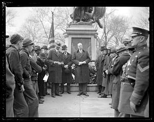 A man speaking to a crowd in front of the Crispus Attucks Monument