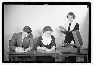A man and a woman listening to a record, possibly taking a test