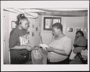 Young woman and adult looking at a notebook