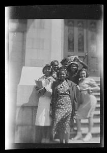 Six women pose on steps
