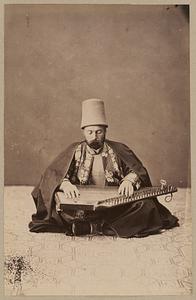 Studio portrait of man playing zither